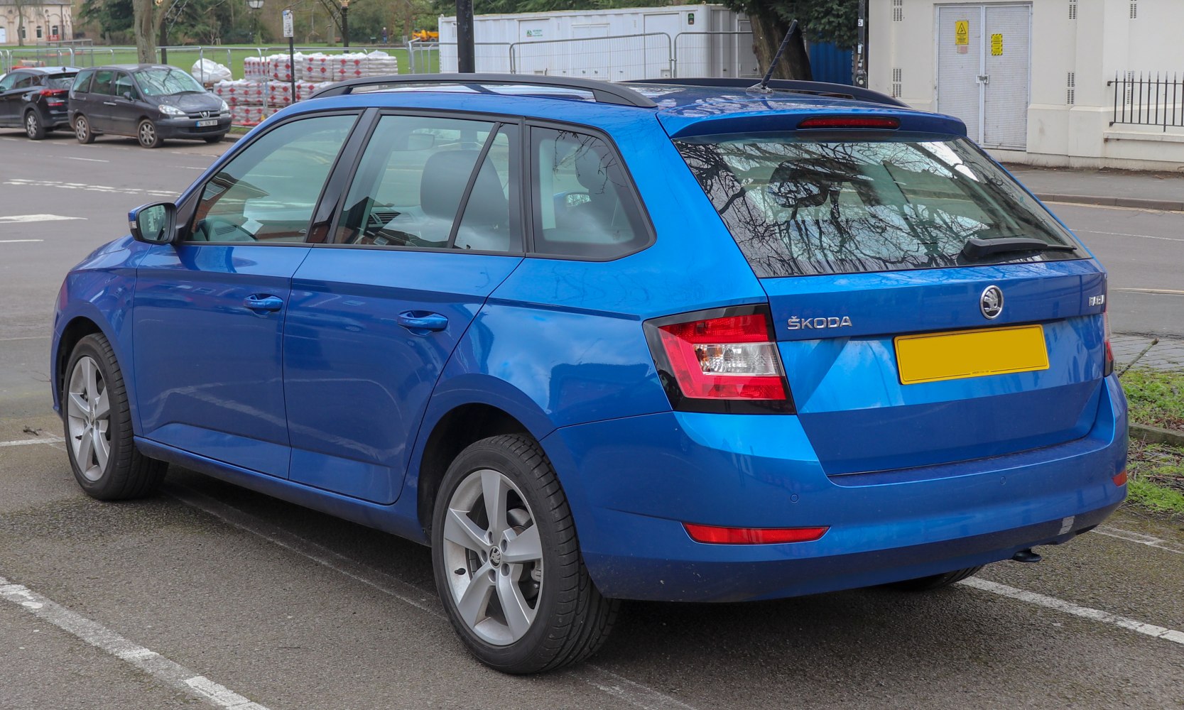 Side and rear view of blue compact estate vehicle with alloy wheels