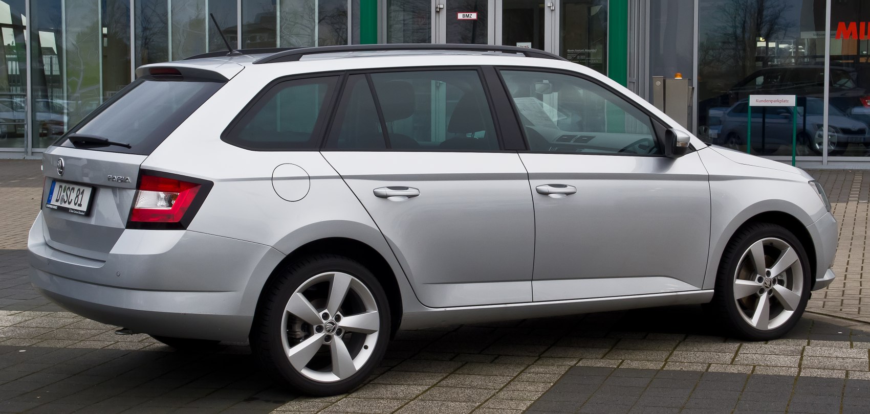 Silver station wagon side view with alloy wheels and roof rails