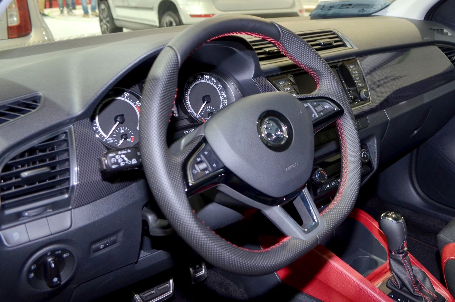 Steering wheel with red stitching and detailed dashboard controls