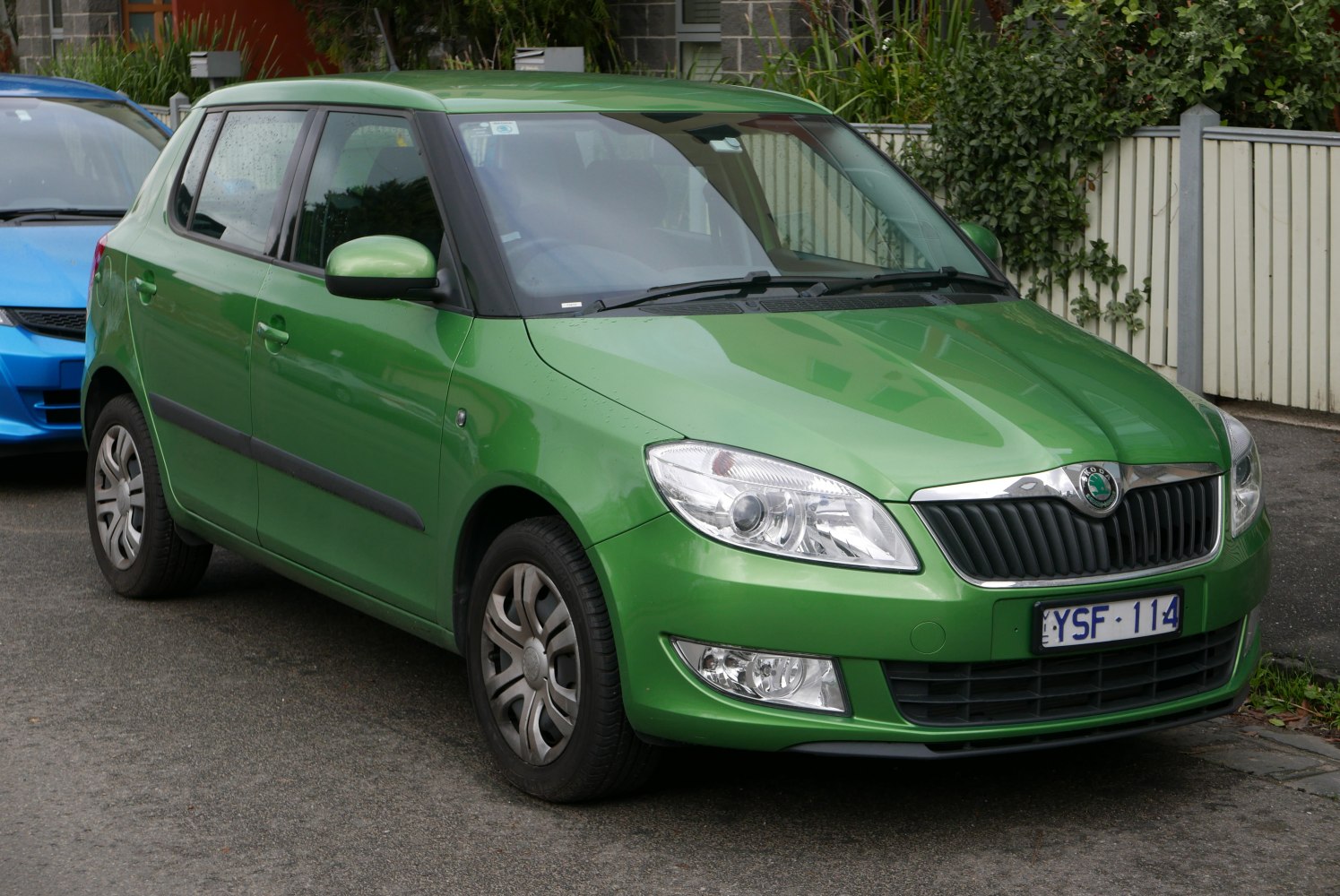 Green hatchback front and side view with distinctive headlights and grille