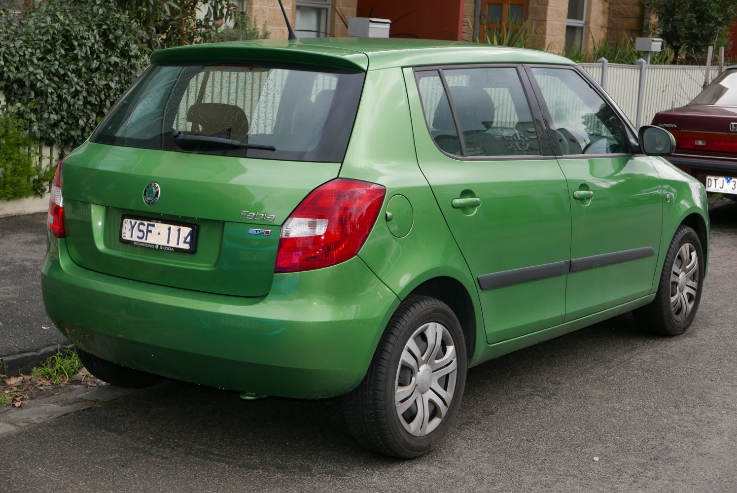 Green hatchback rear and side view with distinct taillights and roof spoiler