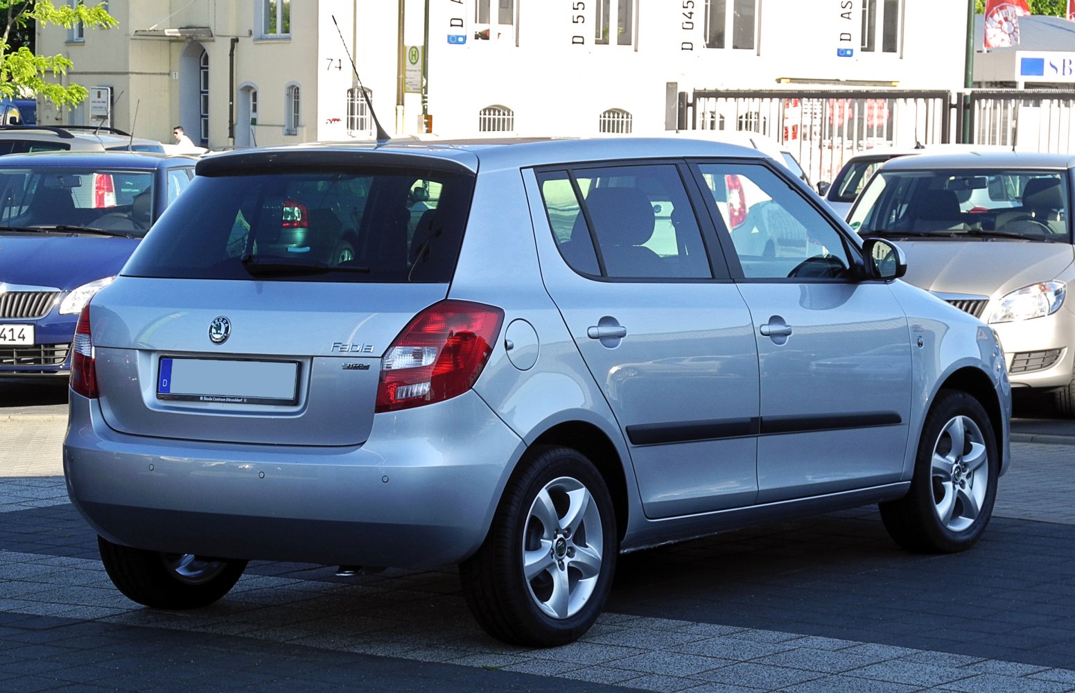 Rear-side of silver hatchback with taillights and alloy wheels