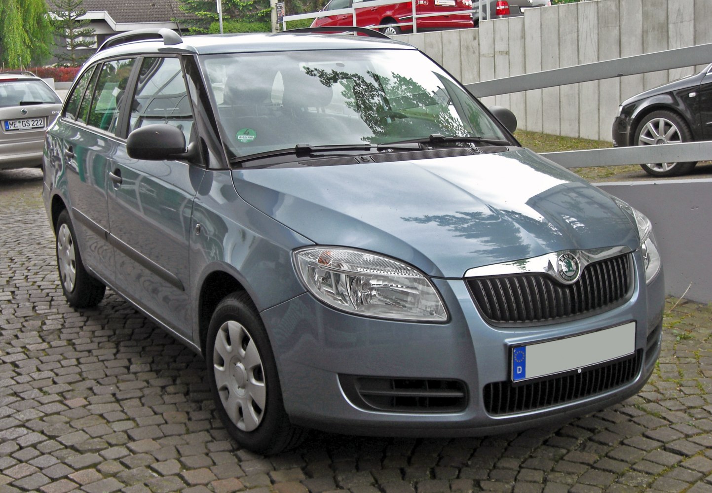 Front and side view of hatchback with roof rails and clear headlights
