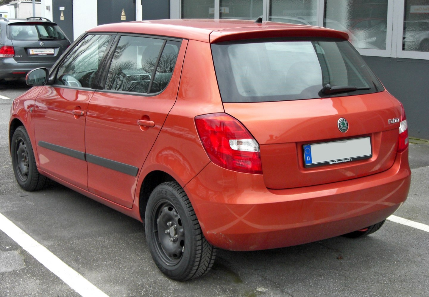 Orange hatchback rear side with visible taillights and five doors