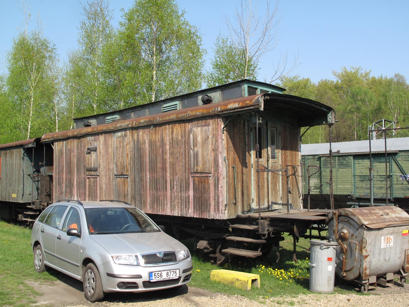 silver compact station wagon parked beside old wooden rail carriage