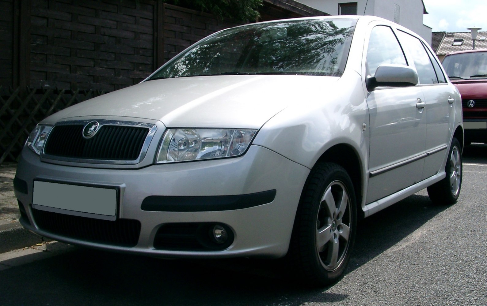 Front view of silver compact hatchback with headlight and grille