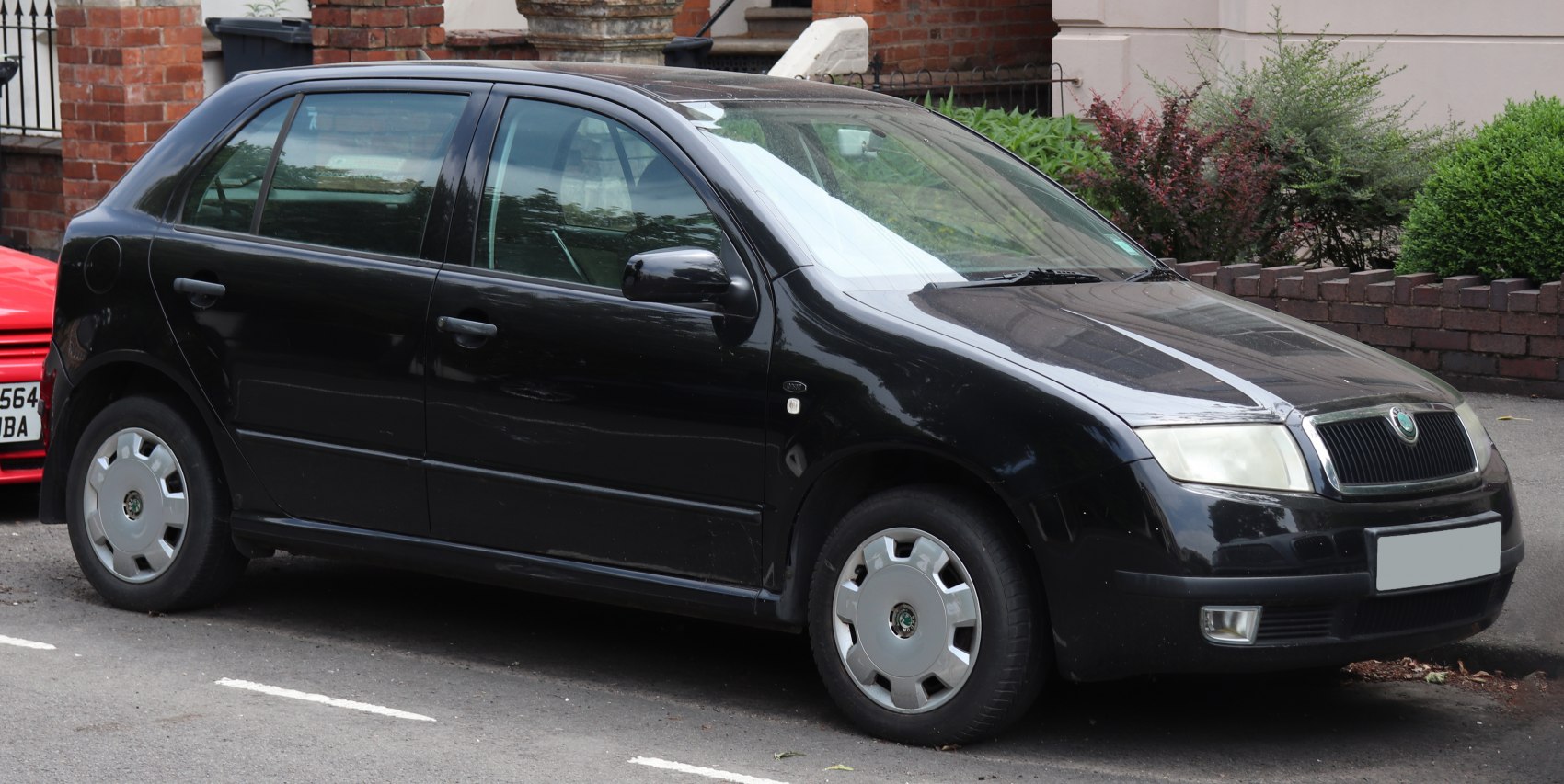 Side profile of a black 1999 hatchback with alloy covers
