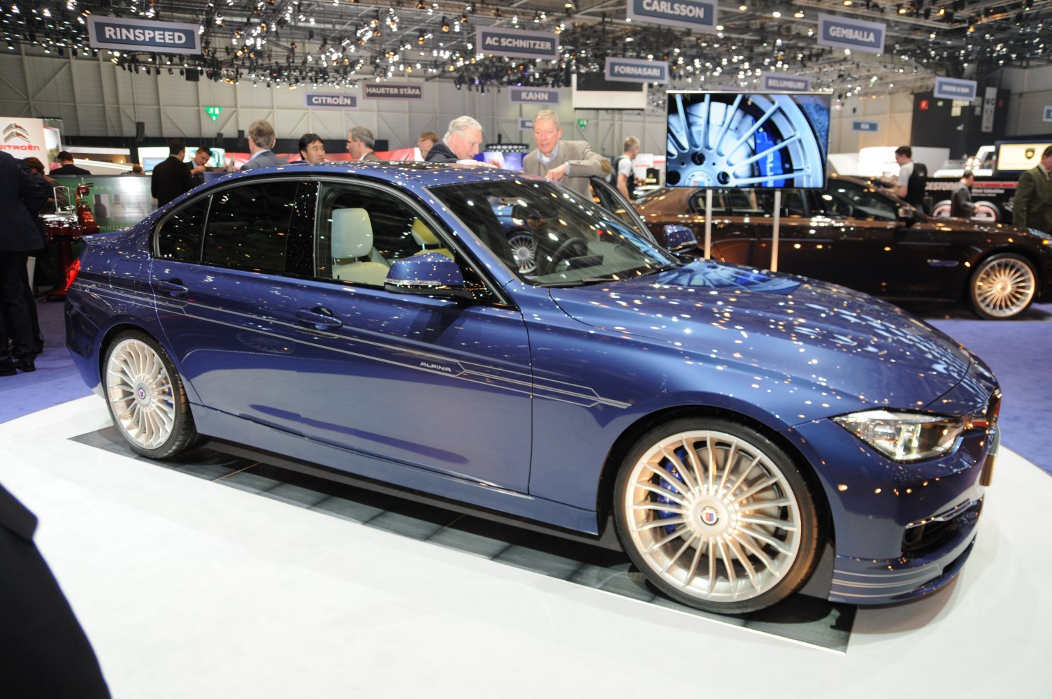 Blue sedan with Alpina multi-spoke wheels and side stripes