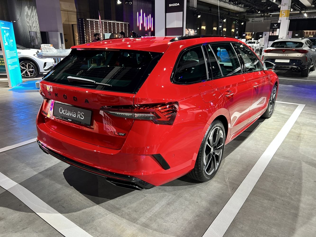 Rear and side view of a sporty red station wagon with sleek body lines and dual exhausts