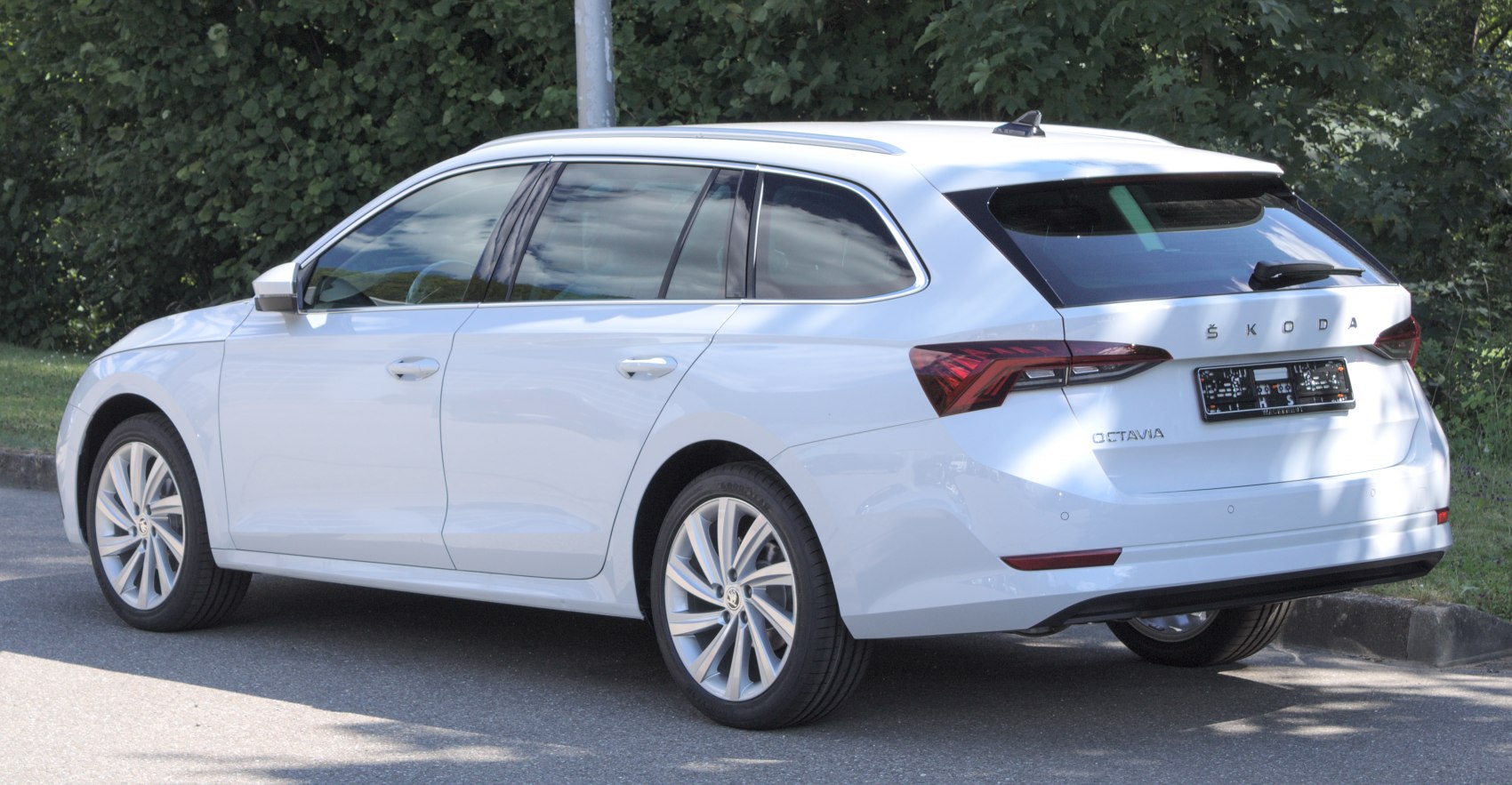White estate car rear side with modern taillights and roof rails