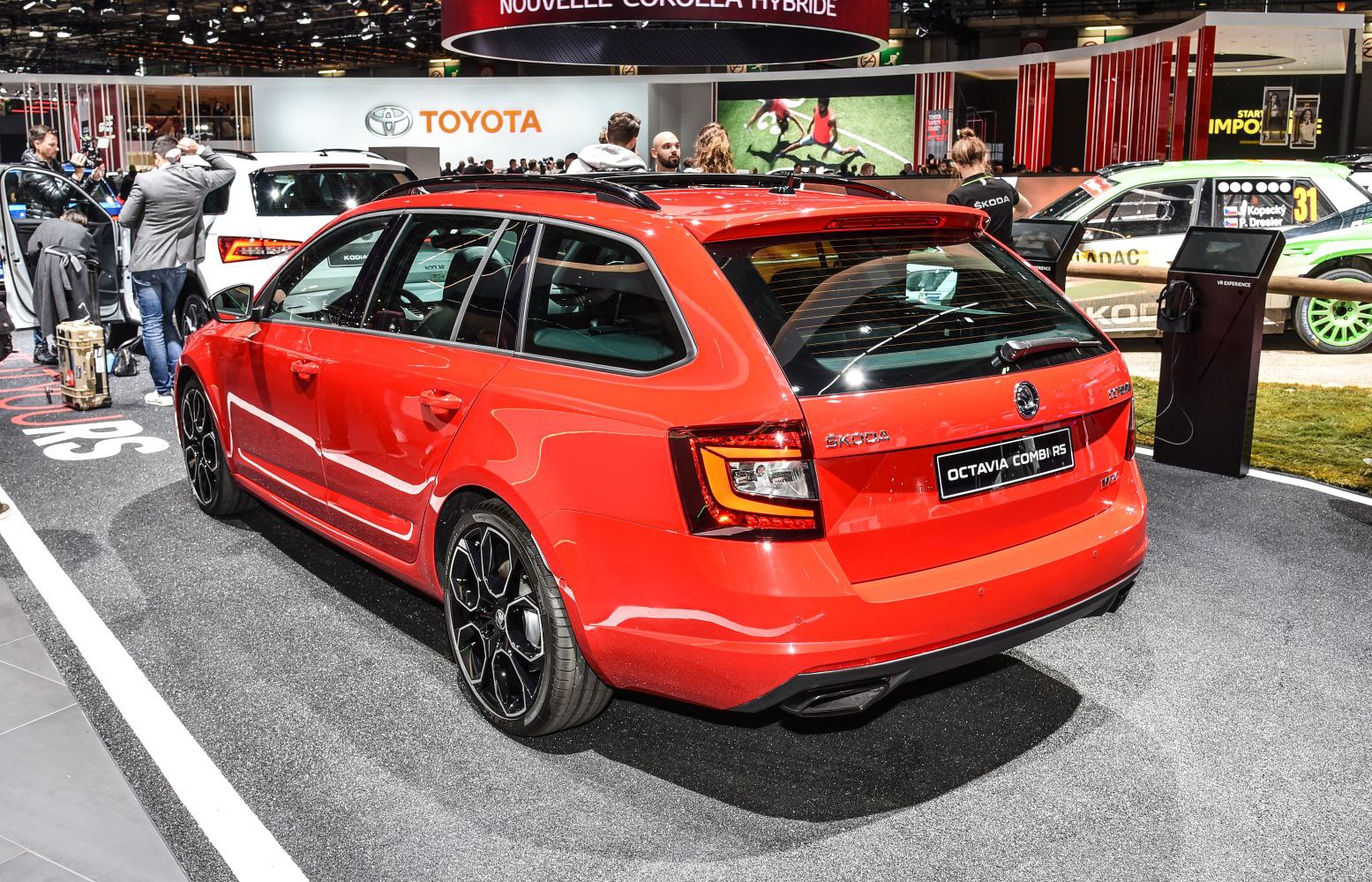 Rear view and side profile of a red station wagon with distinctive tail lights and sporty wheels