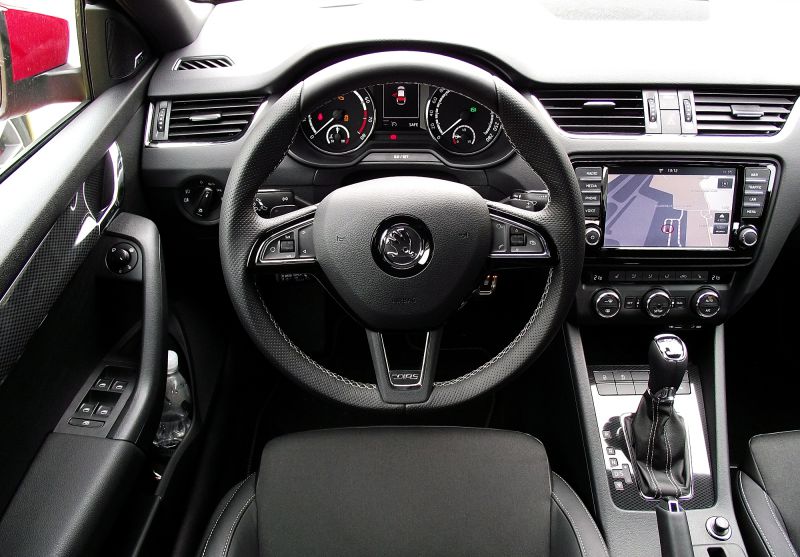 Interior with multifunction steering wheel, dashboard gauges, and infotainment system