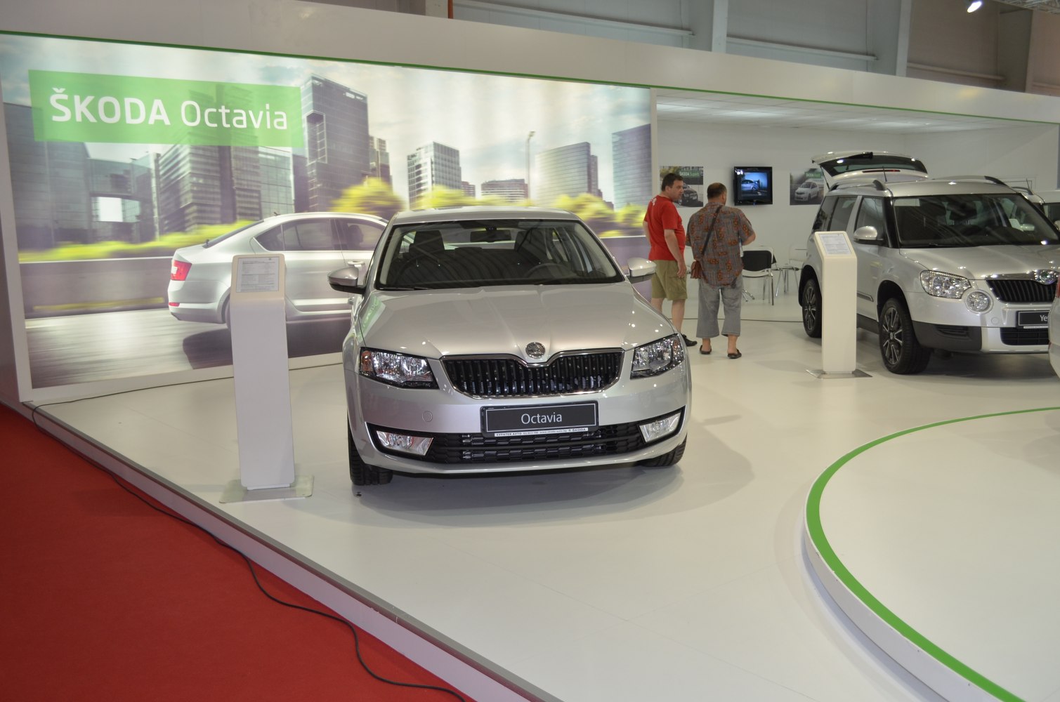 Front view of silver sedan with distinct grille and headlights in exhibition