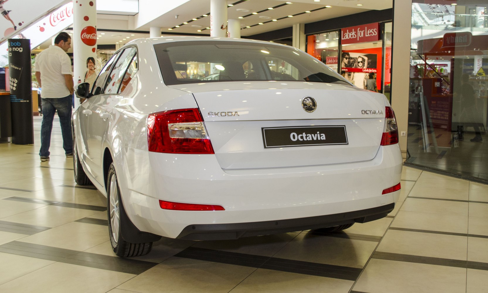 White sedan rear view with modern taillights in indoor showroom