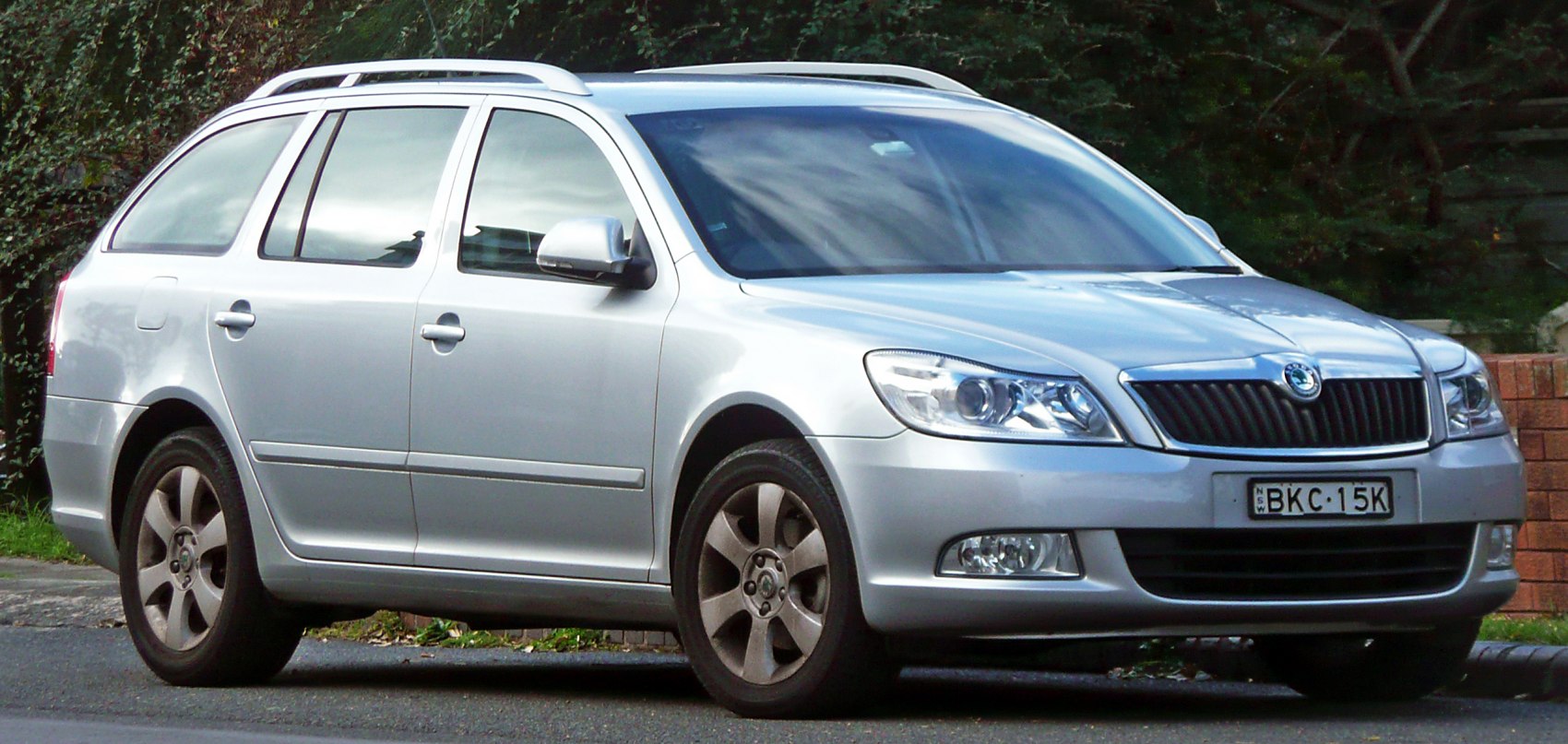 Silver station wagon with roof rails and alloy wheels, front and side view.