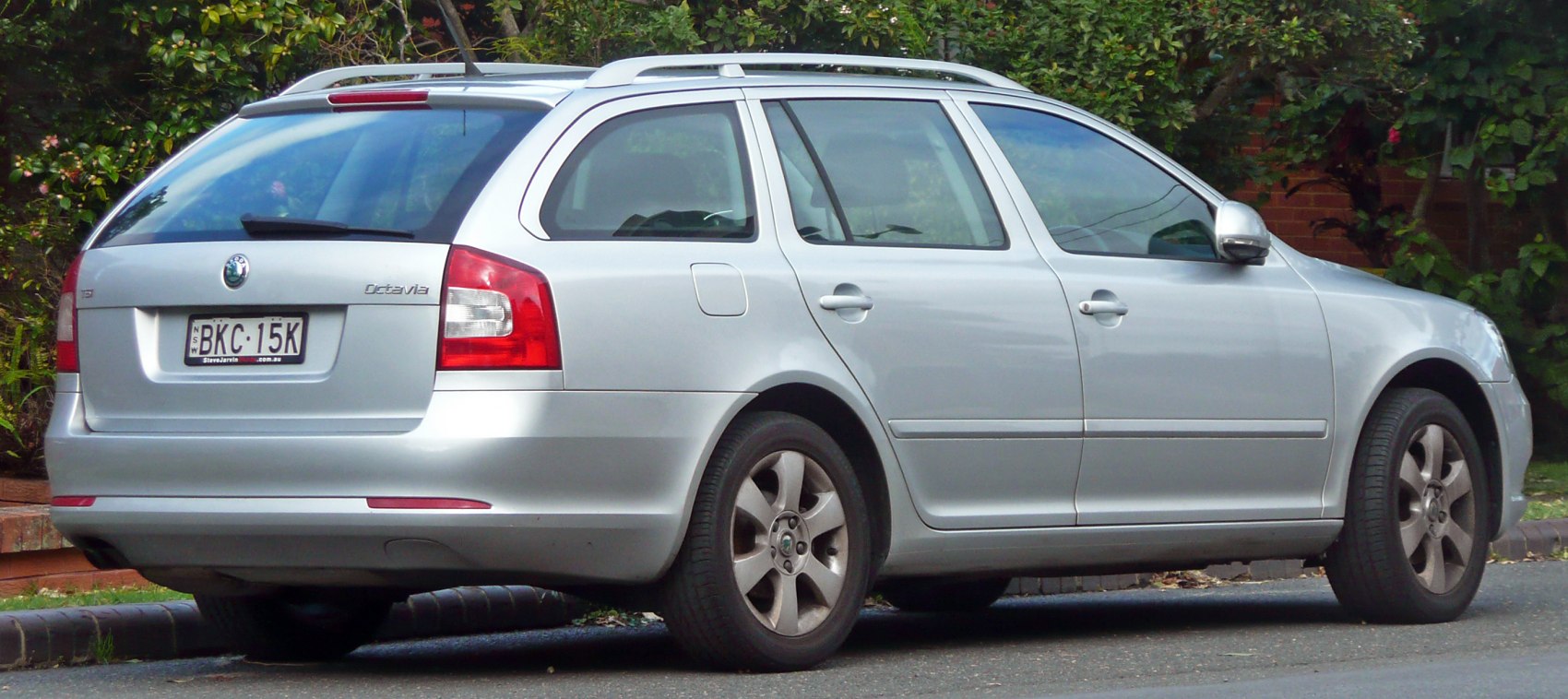 Rear and side profile of silver estate car with roof rails and distinct tail lights