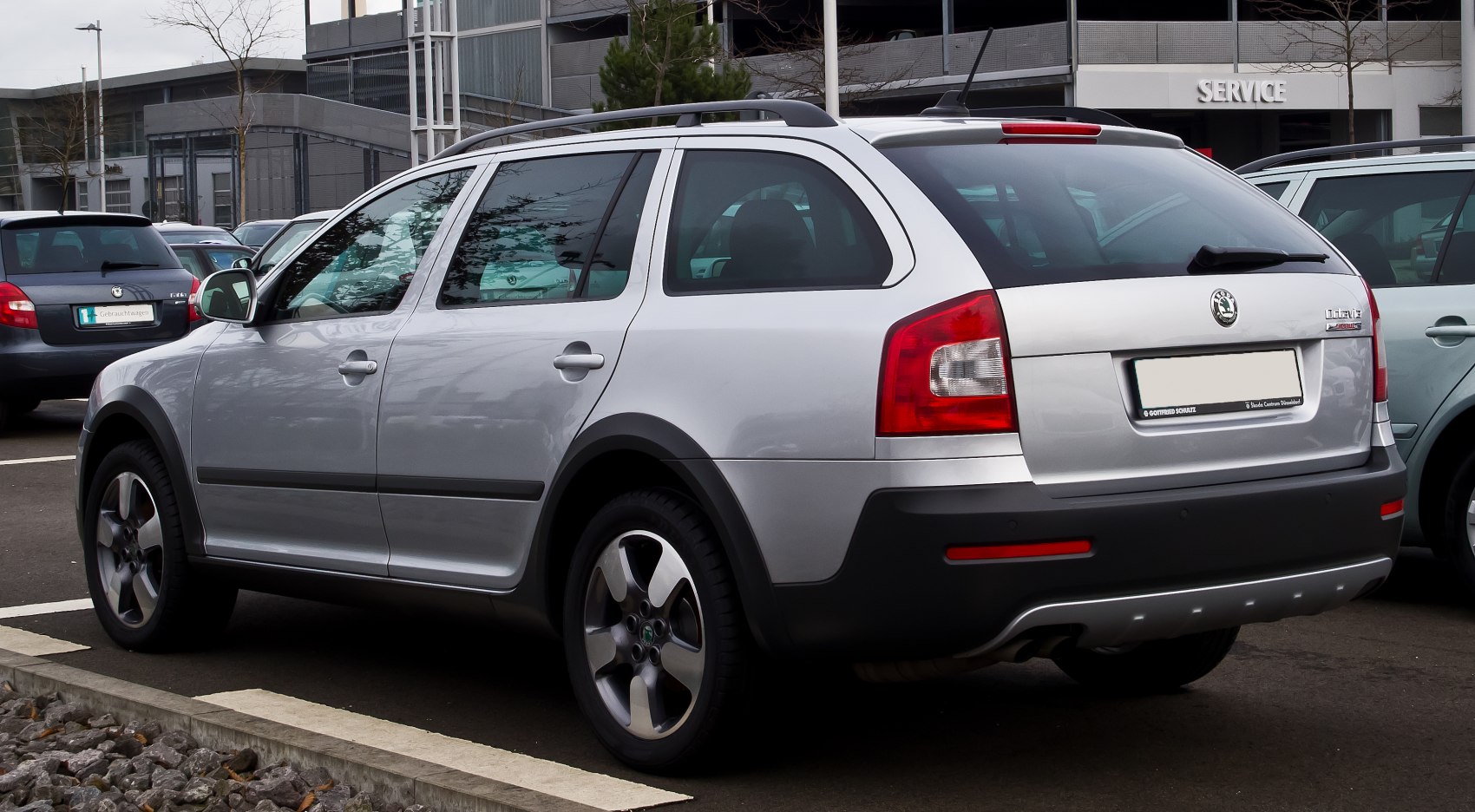 Silver station wagon with roof rails and alloy wheels, rear side angle