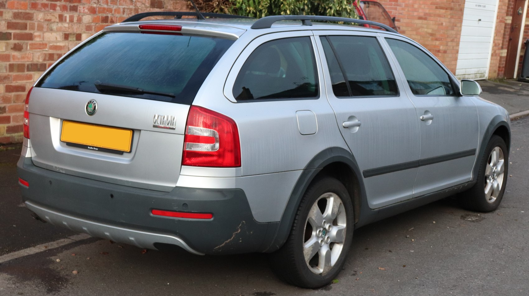 Rear side of a silver estate car with roof rails and alloy wheels