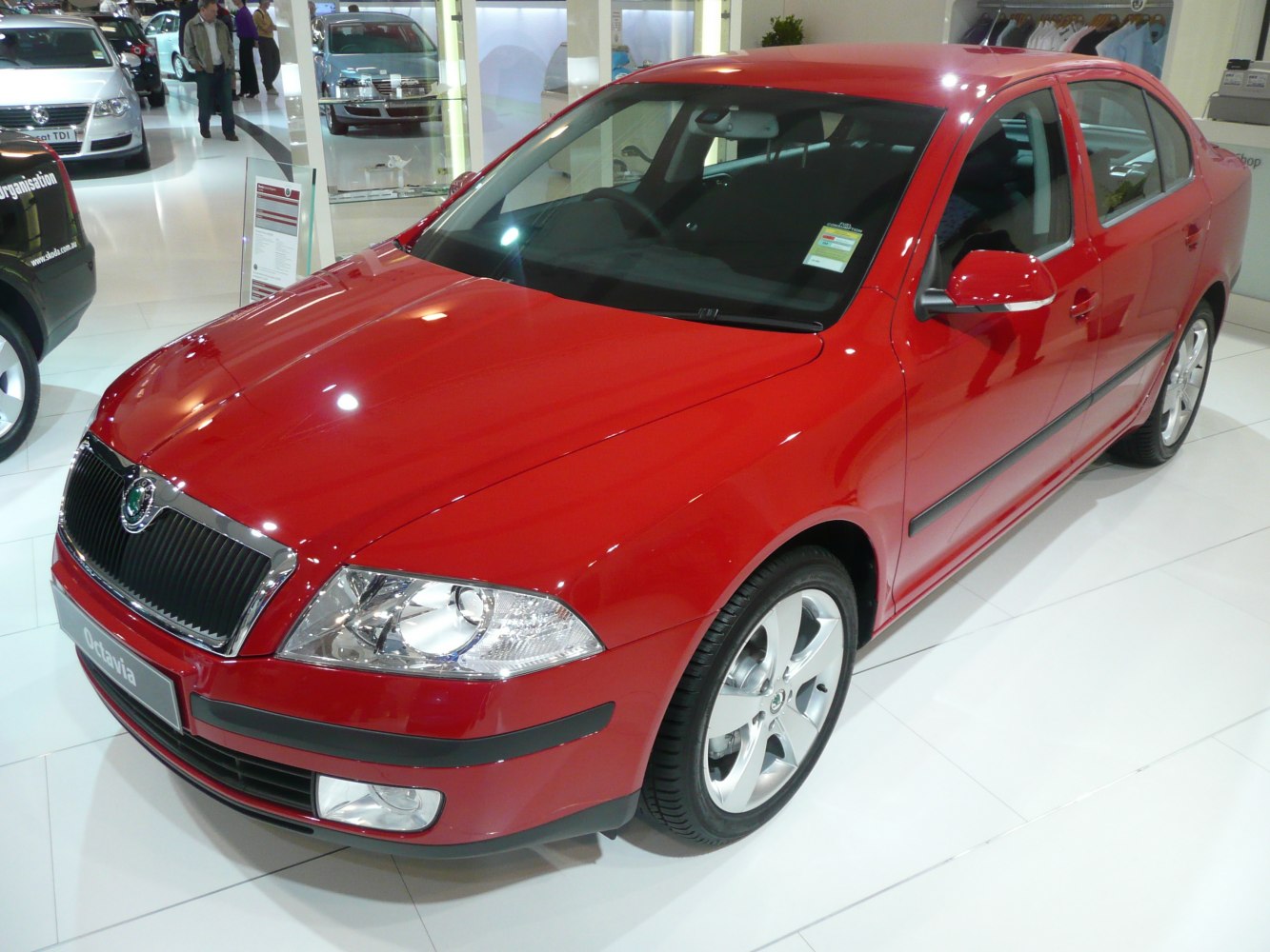 Front-side view of red sedan highlighting headlights and grille