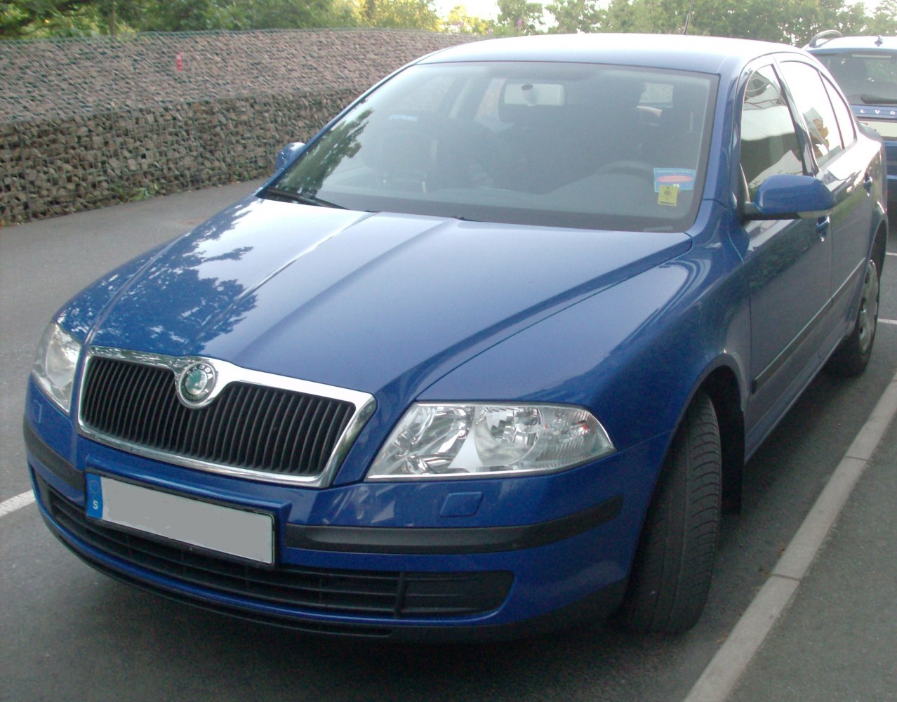 Front angle showcasing grille and headlights of blue sedan