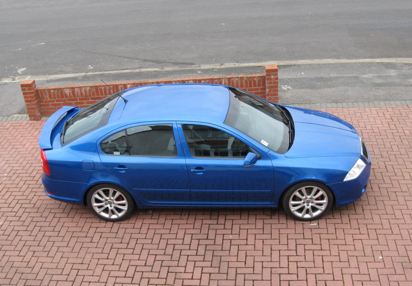 Sporty blue sedan with rear spoiler and alloy wheels