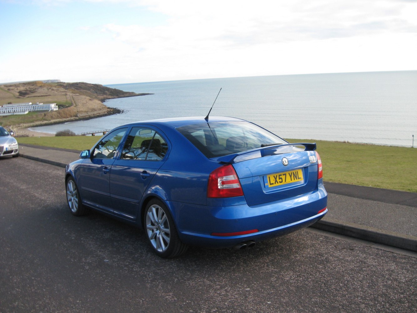 Blue sedan with rear spoiler and dual exhaust