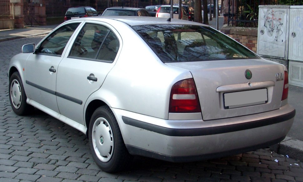 Rear view of classic 1990s four-door sedan with distinctive tail lights and silver paint.