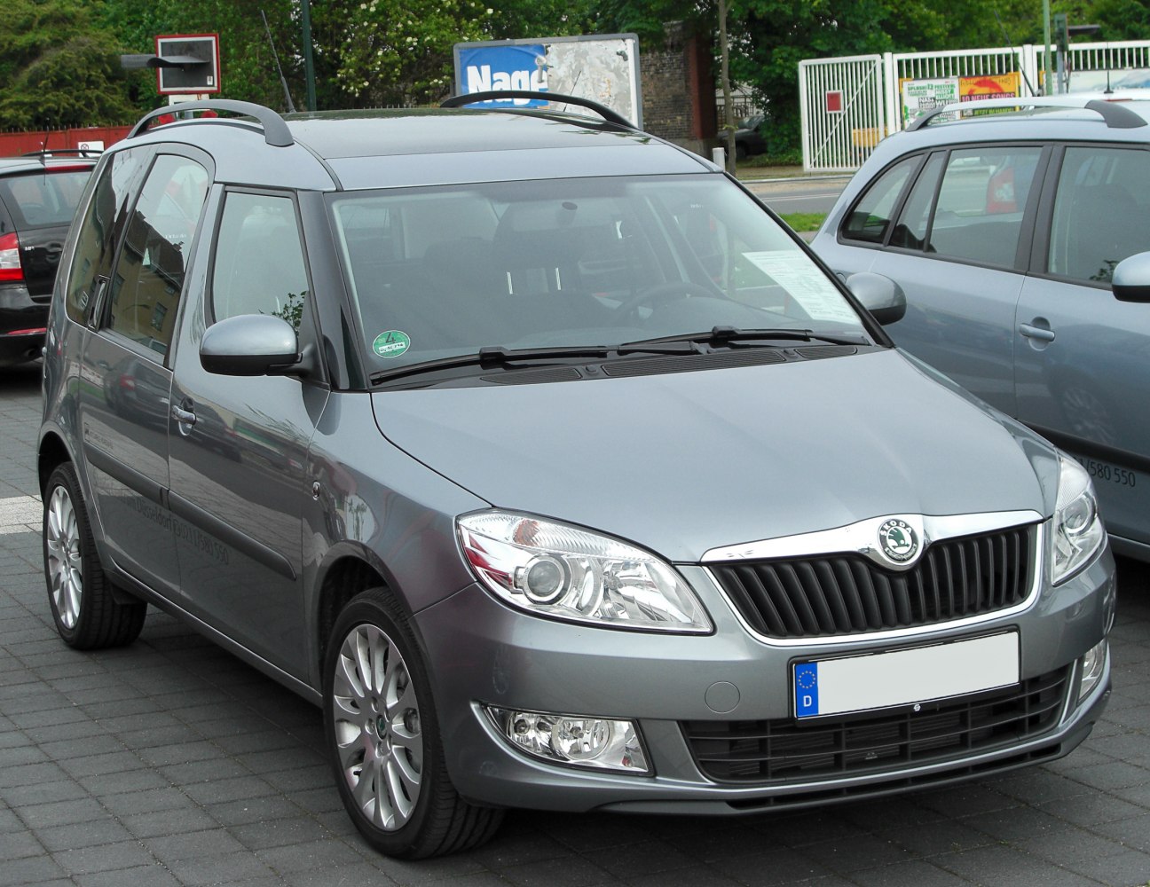 Front view with headlights, grille, roof rails, and alloy wheels