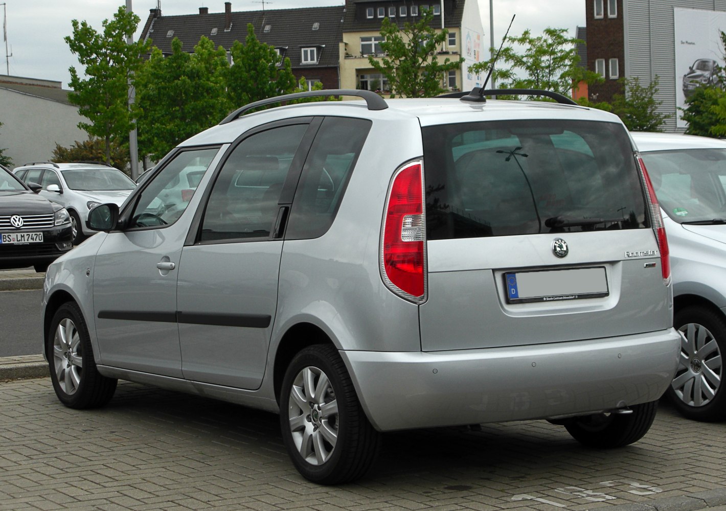 Rear side view with vertical taillights and roof rails of a compact MPV.
