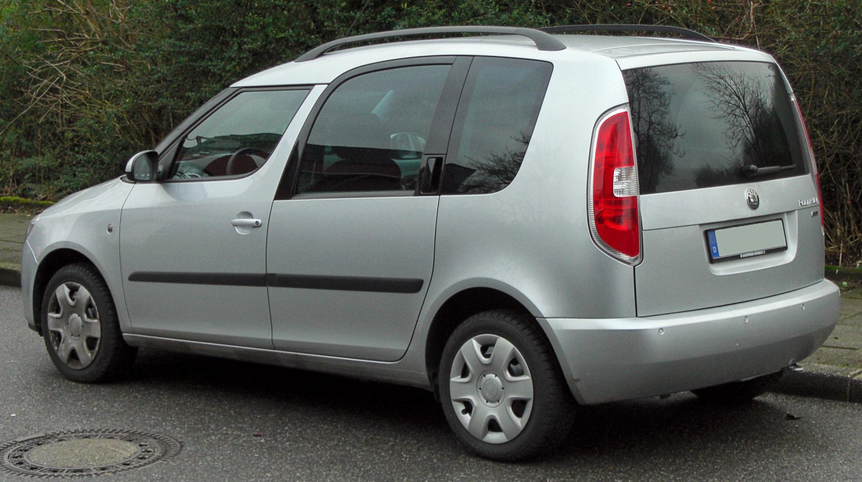 Silver MPV with sliding rear door and tall vertical tail lights