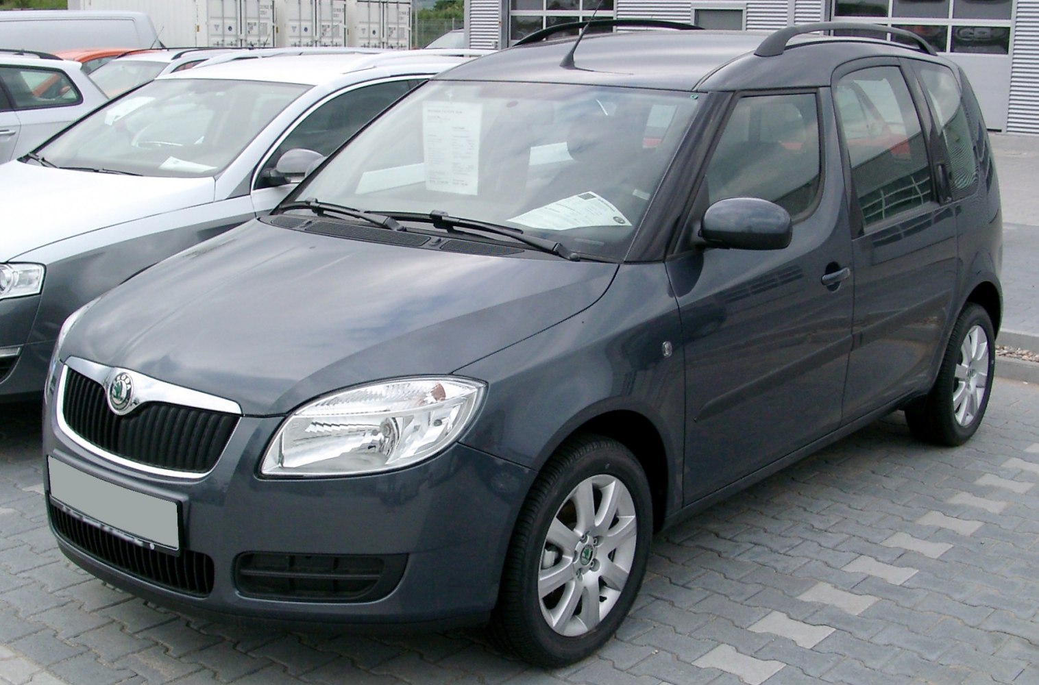 Compact MPV with front headlights, grille, alloy wheels, and roof rails