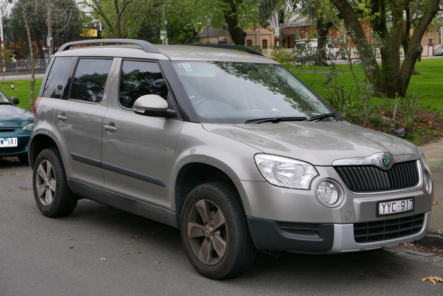 Front and side view of compact SUV with round fog lights and roof rails.