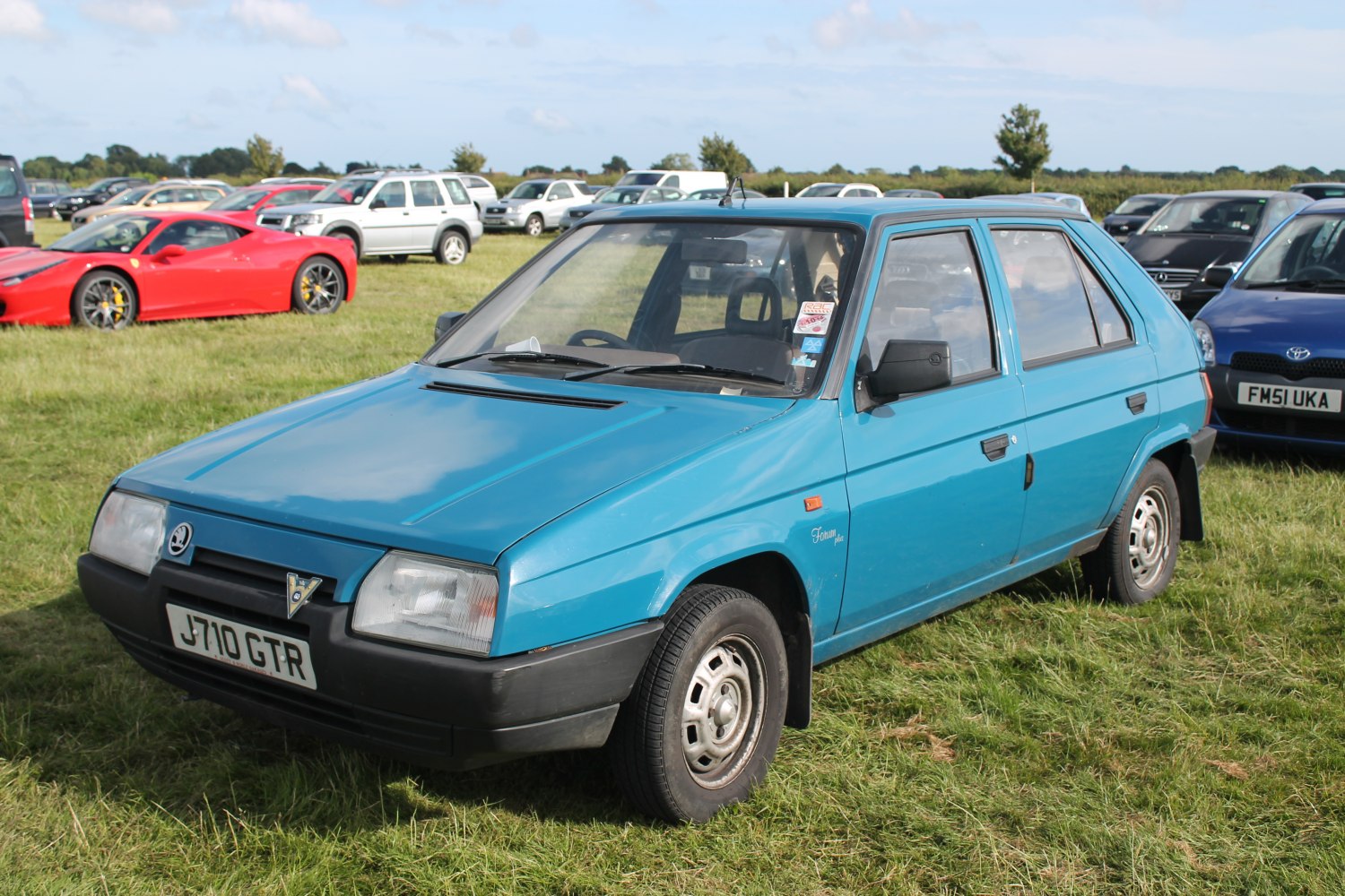 Blue angular 1990 hatchback with boxy shape and classic headlights