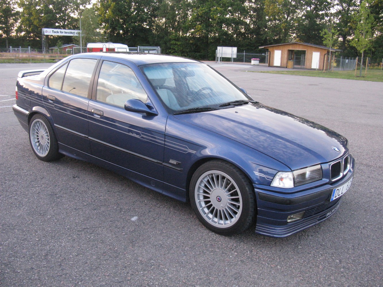 Vintage sedan with multi-spoke wheels and sporty body kit details