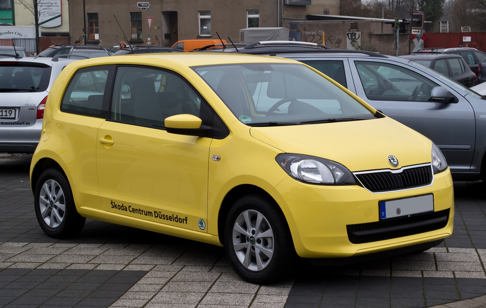 Yellow compact 3-door car with alloy wheels and distinct front grille.