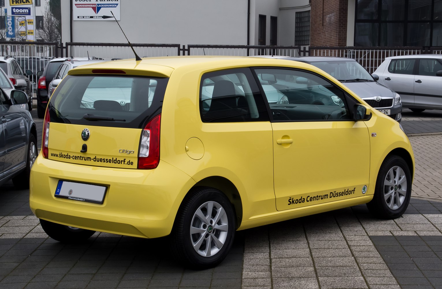 Yellow 3-door hatchback with alloy wheels and prominent rear tail lights