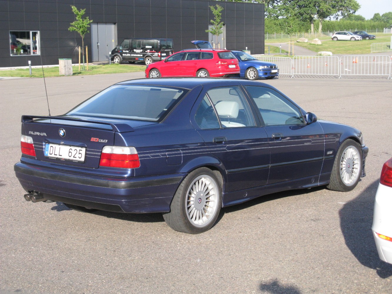 Rear side view showing sedan rear spoiler and Alpina multi-spoke rims