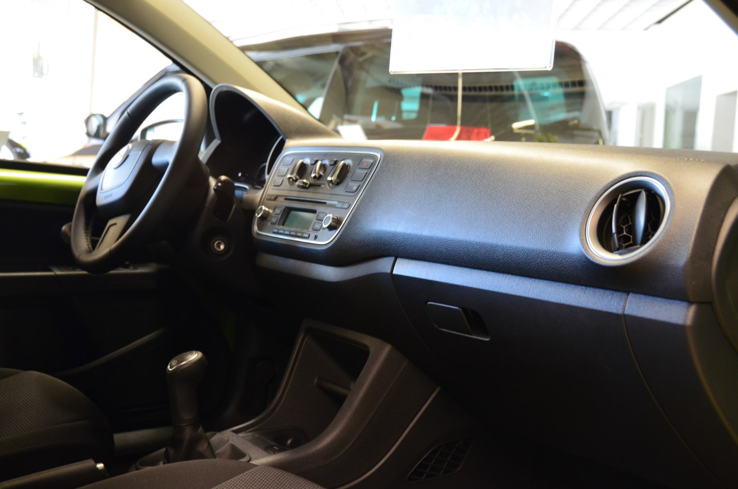 Compact car dashboard with control panel, steering wheel, and air vents
