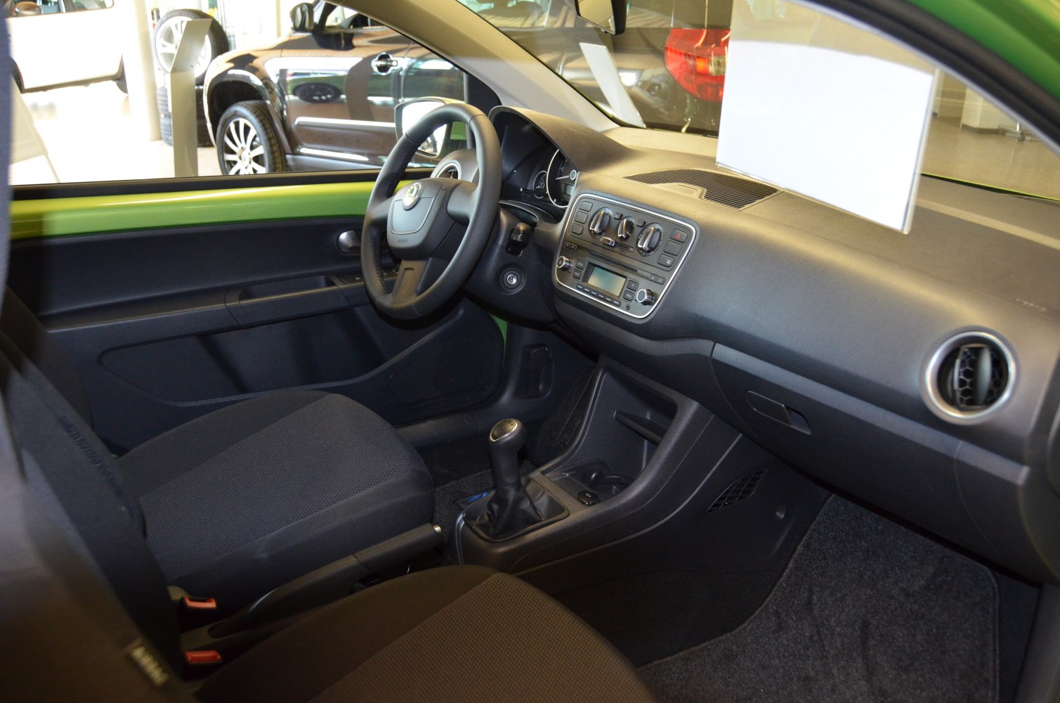Dashboard and interior of a compact car with manual transmission.