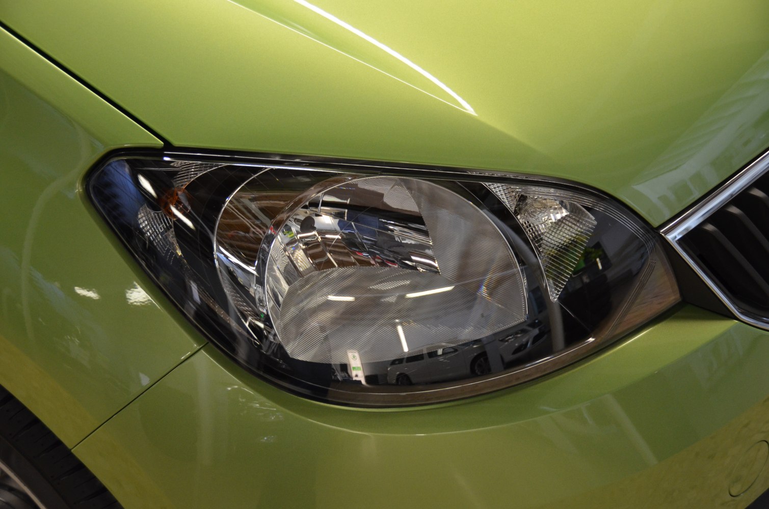 Close-up of a car headlight on front fender and bumper