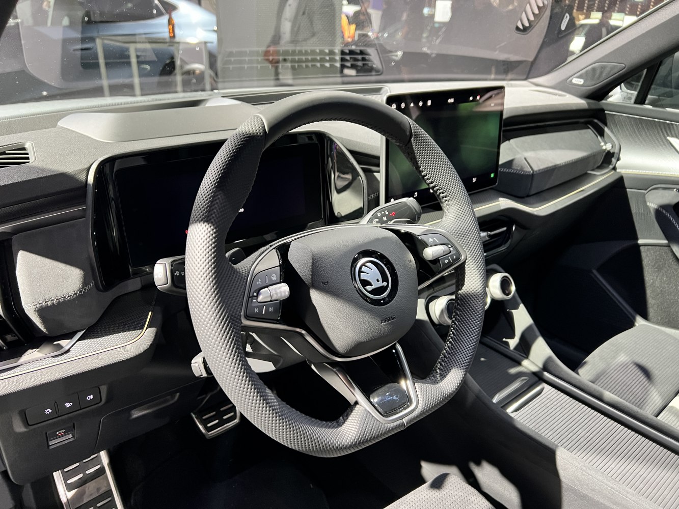 Modern steering wheel and digital dashboard with touchscreen.