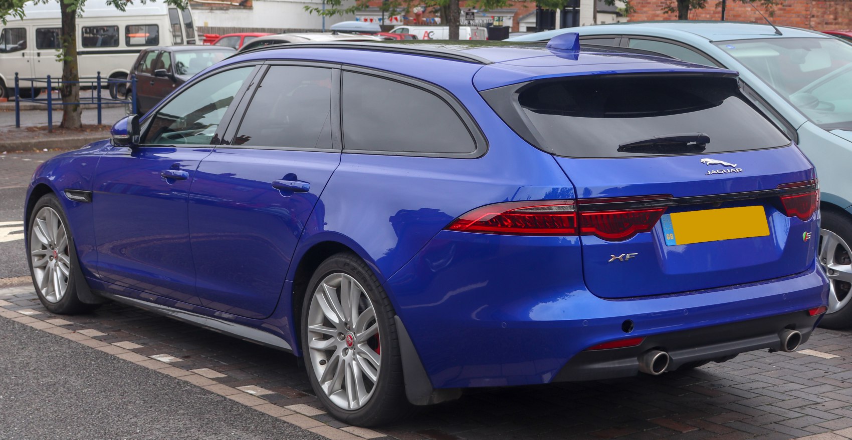Blue estate car rear side with sleek taillights and dual exhausts