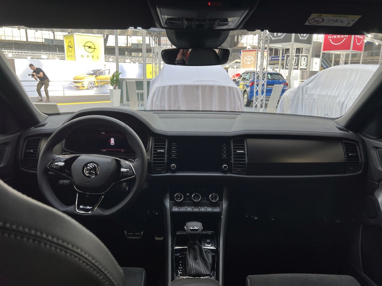 Black dashboard and multifunction steering wheel with center console and gear shifter.
