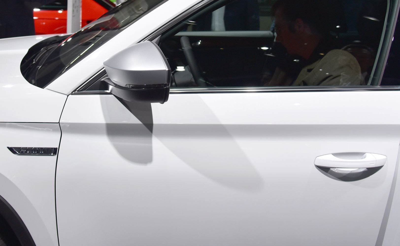 Close-up of white side door and silver side mirror