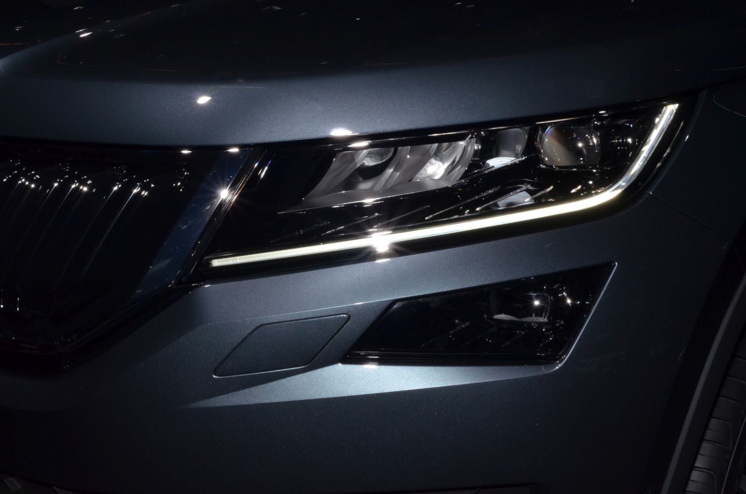 Front LED headlight and grill close-up with sleek modern design