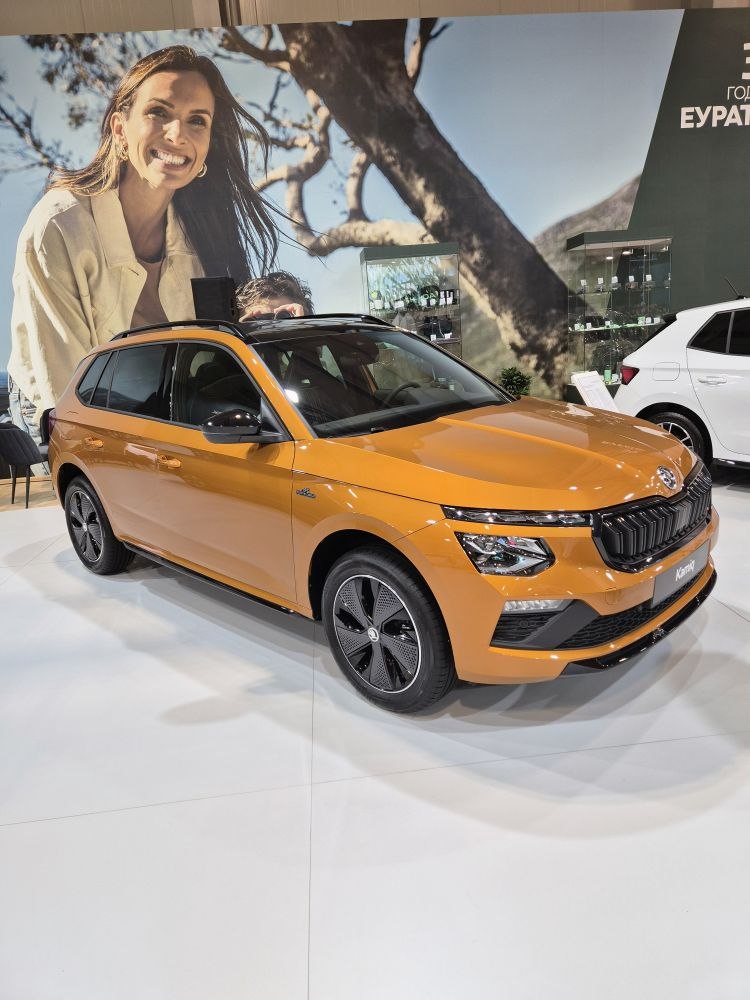 Front side view of orange SUV with distinct headlights and black grille