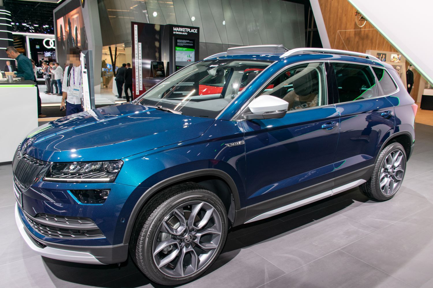 Front side view of blue SUV with alloy wheels and distinctive headlights