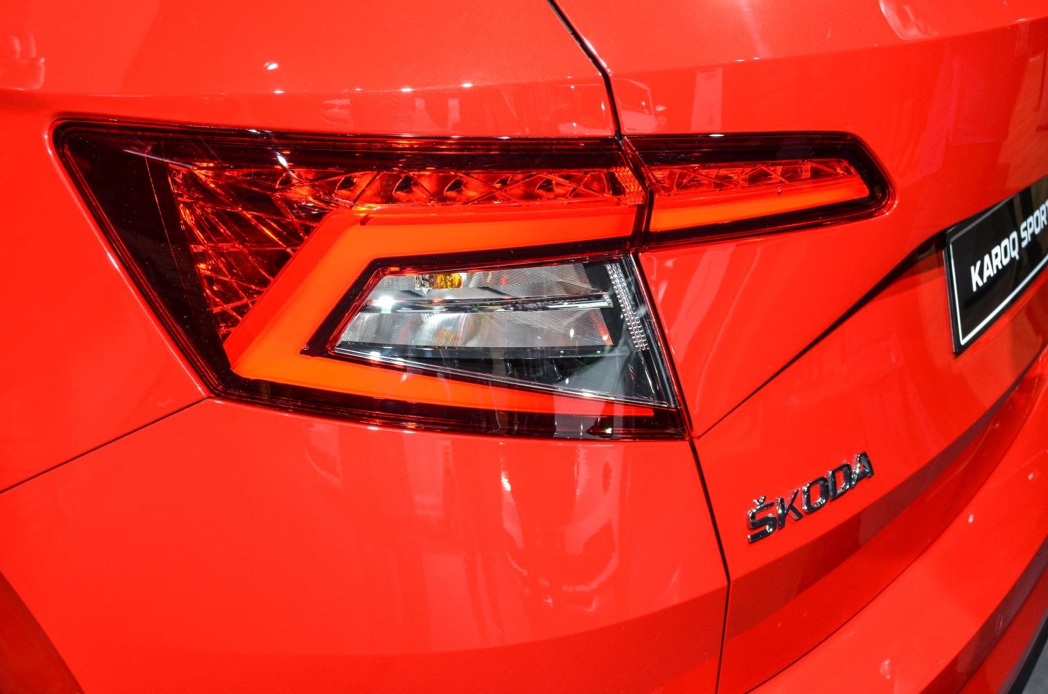 Close-up of rear tail light and badge on red vehicle