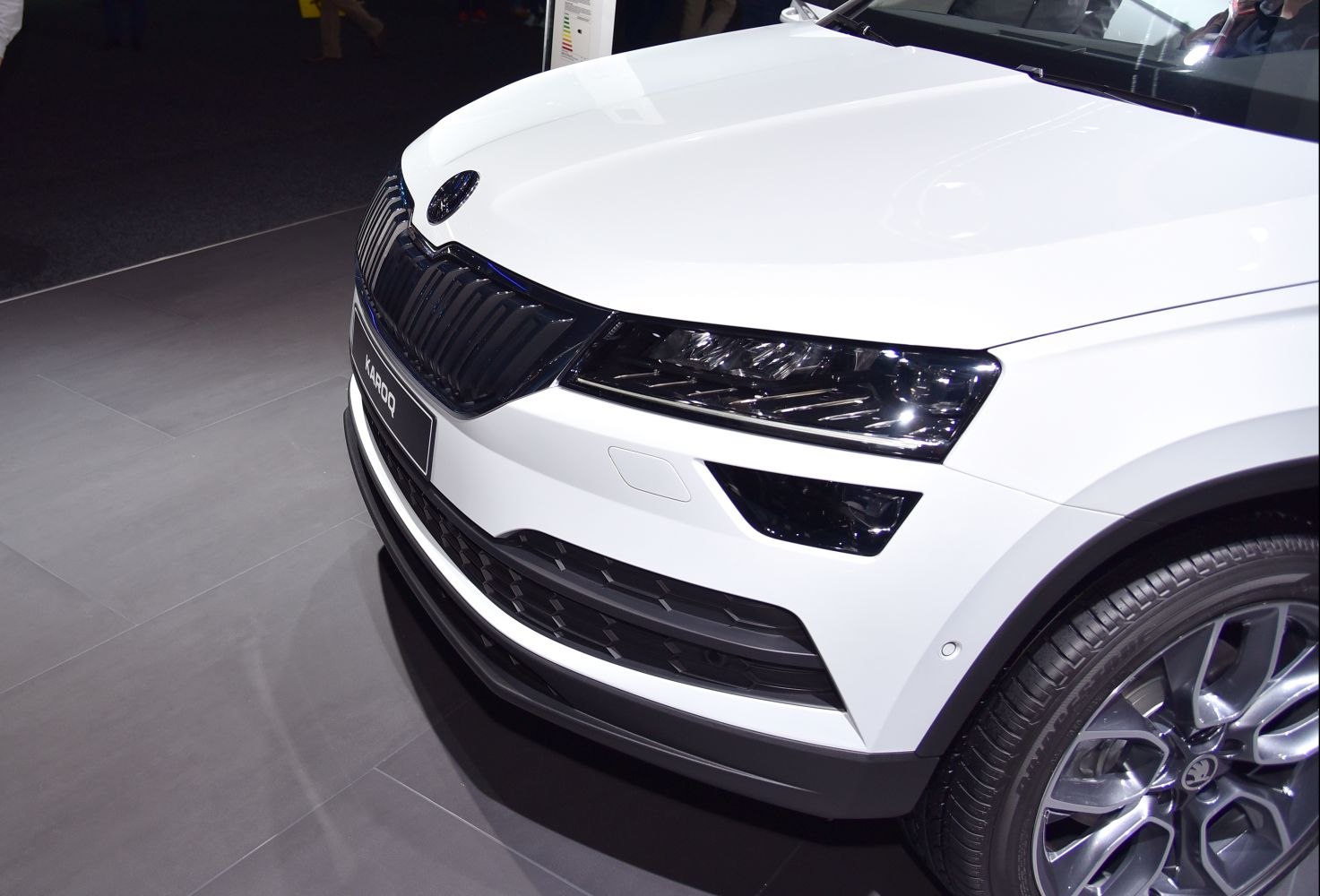 Close-up of front grille, headlights, and wheel of modern SUV.