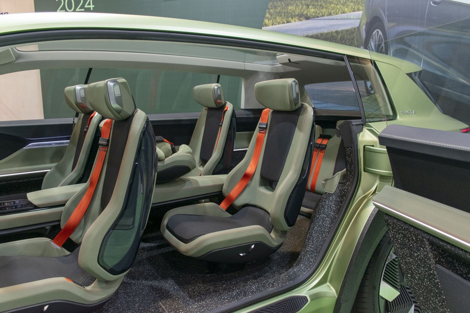 Futuristic green seats with orange seatbelts inside spacious modern cabin